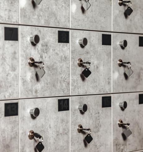 Close-up of rows of numbered grey mailbox with keys in modern design build Close-up of rows of numbered grey mailbox with keys in modern design build. Storing personal items and information in mailboxes indoors. Security and safety backgrounds concept. Copy ad text space