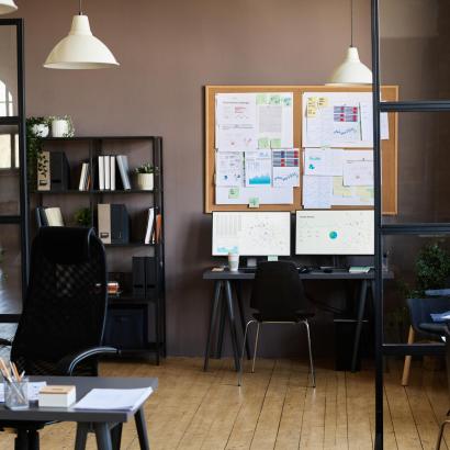 Modern office with workplaces of employees Image of modern office with workplaces of employees with computers on them and board with documents hanging on wall